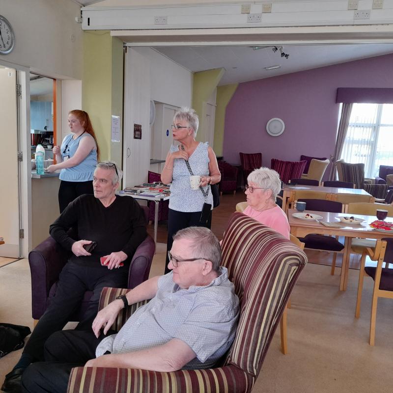 two men and three women in a room