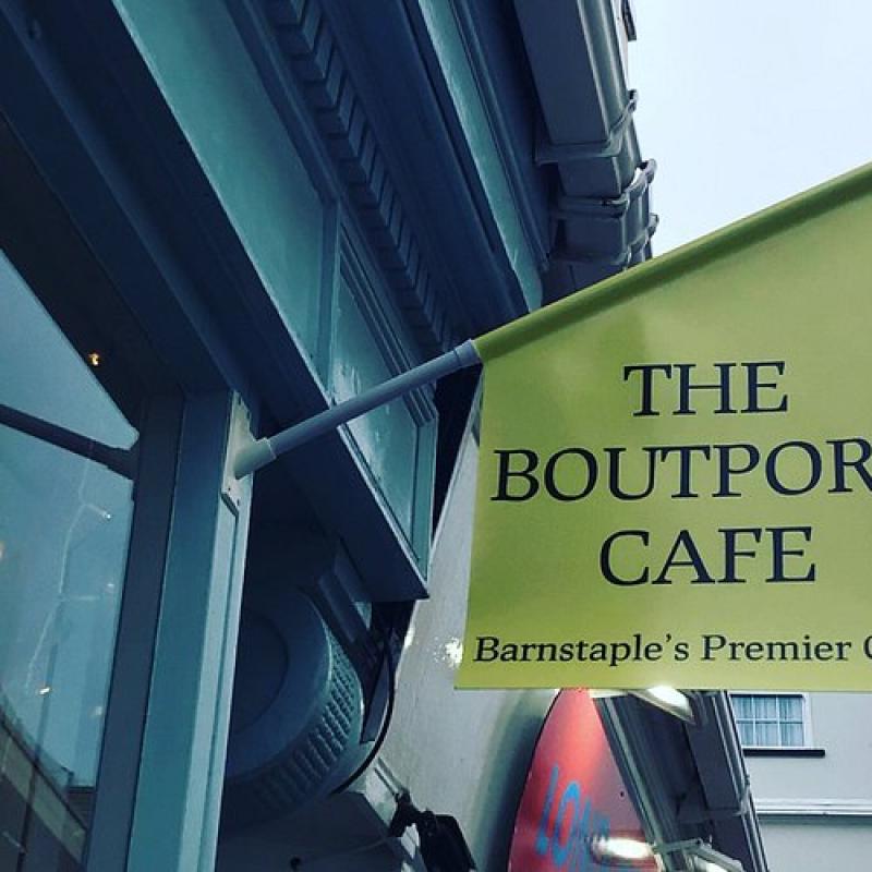 A flag attached to a building which reads 'The Boutport Cafe'