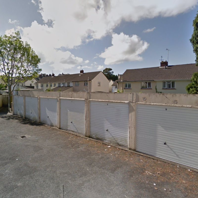A row of garages with white doors, all closed