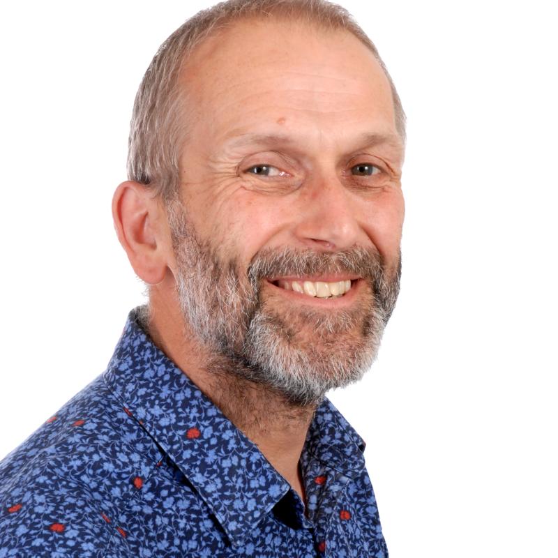 Smiling, bearded man in blue shirt